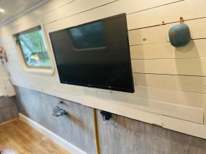 a flat screen tv on the wall of a trailer at BespokeNarrowBoat in Manchester