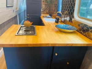 a kitchen with a wooden counter top with bowls on it at BespokeNarrowBoat in Manchester +7 photos