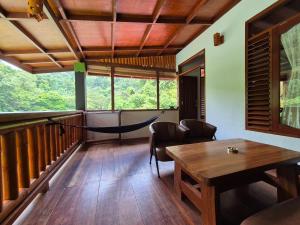 Habitación con hamaca, mesa y sillas. en Sam's Bungalows And Treks, en Bukit Lawang