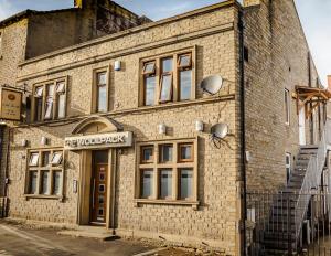 an old brick building with a sign on it at WoolPack By SAFÉRA in Huddersfield