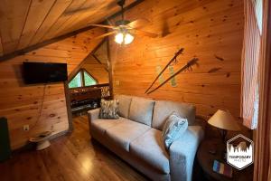 a living room with a couch and a ceiling fan at Tree Top Hideaway - Private with Games Firepit More in Blue Ridge