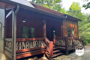 a log cabin with a large wooden porch and a porch at Tree Top Hideaway - Private with Games Firepit More in Blue Ridge