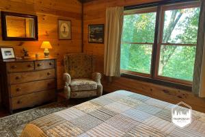 a bedroom with a bed and a chair and a window at Tree Top Hideaway - Private with Games Firepit More in Blue Ridge