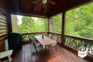 a screened in porch with a table and chairs on it at Tree Top Hideaway - Private with Games Firepit More in Blue Ridge