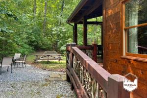 a log cabin with a porch and a table and chairs at Tree Top Hideaway - Private with Games Firepit More in Blue Ridge