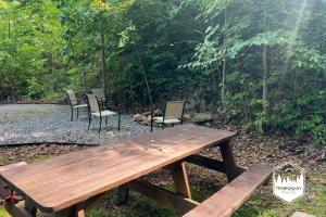 a wooden picnic table and chairs in a yard at Tree Top Hideaway - Private with Games Firepit More in Blue Ridge