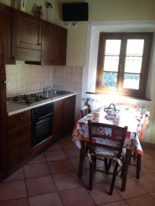 a kitchen with a table and a stove at Agriturismo La Buca in Cutigliano