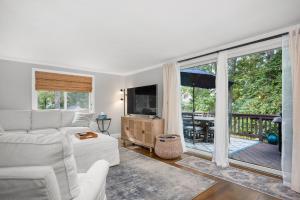 a living room with a white couch and a sliding glass door at 10 Seventh Street Harwich Cape Cod- -Cape Vista in Harwich