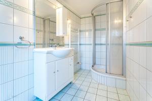 ein weißes Badezimmer mit Waschbecken und Dusche in der Unterkunft Achtern in Heringsdorf