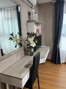 a dining room table with a vase of flowers on it at 501B #1km to central festival #5 km to lee garden in Ban Khlong Wa