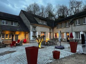 a large building with a courtyard with tables and chairs at demeure de luxe, piscine sauna billard pétanque in Yèvre-le-Châtel