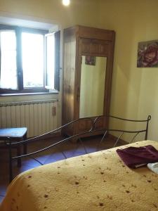 a bedroom with a bed and a window at Agriturismo La Buca in Cutigliano