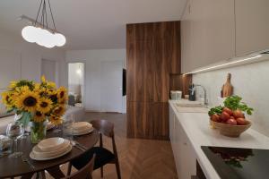 a kitchen with a table with a vase of flowers at Apartament Sienkiewicza 22B in Zamość