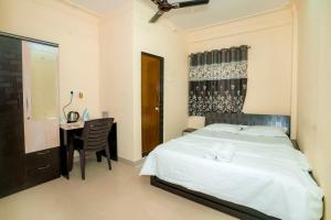 a bedroom with a bed and a desk and a table at Paradise Homestay - Lodging and Boarding in Pune