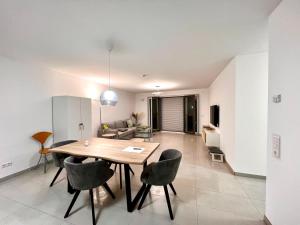 a dining room and living room with a table and chairs at Özels Designer Loft Metzingen - Smart TV, Netflix, private kostenlose Tiefgarage, Self-Express Check-in,Check-out, Outlet 100m in Metzingen