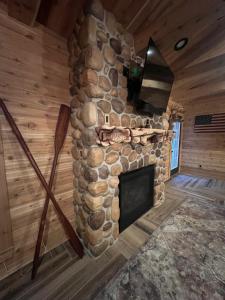 a room with a stone fireplace in a log cabin at Cozy Cabin Retreat for Your Perfect Getaway in Imperial +18 photos