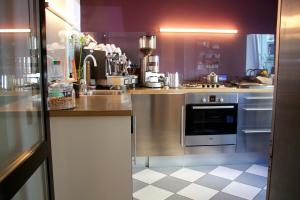 cocina con electrodomésticos de acero inoxidable y suelo a cuadros en Schlaflounge, en Hamburgo