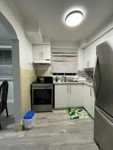 a kitchen with white cabinets and a stainless steel refrigerator at Toronto Midtown Room with Queen Bed in Toronto