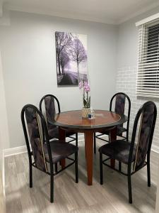 a dining room table and chairs with a vase of flowers on it at Toronto Midtown Room with Queen Bed in Toronto