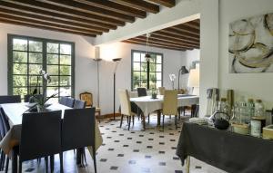 a dining room with tables and chairs and windows at Beautiful Home In Yèvre-La-Ville in Yèvre-la-Ville