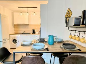 una cucina con tavolo in legno e stoviglie di Chez Lulu - 5 lits- proche CNPE - Gare a Ambérieu-en-Bugey