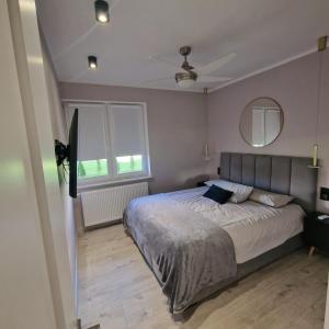 a bedroom with a large bed and a mirror at APARTAMENT OFELIA in Darłówko