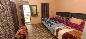a bedroom with two beds and a window at Shree Gopal Niketan in Mathura