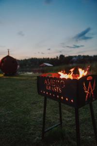 a sign in front of a fire in a field at Ambro Krasts in Maskava