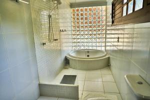 a white bathroom with a tub and a sink at Casa Barra Nova in Cascavel +19 photos