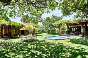 een achtertuin met een tafel en stoelen en een parasol bij Casa Barra Nova in Cascavel