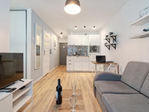 グディニャにあるGdynia Seaside Apartment - Balcony, Workspace, Bus - by Rentujemyのソファとテーブルのあるリビングルーム