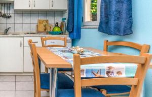 a kitchen with a wooden table and two chairs at 1 Bedroom Awesome Apartment In Turanj in Turanj +8 photos