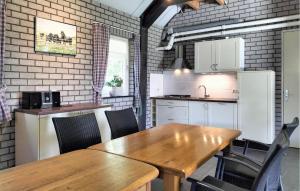 a kitchen with a wooden table and chairs at Lovely Home In Boekel With Sauna in Boekel