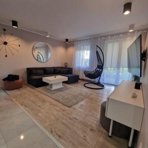 a living room with a couch and a table at APARTAMENT OFELIA in Darłówko