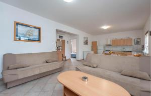 a living room with two couches and a table at Beach Front Apartment in Sveti Filip i Jakov