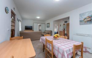 a dining room with a table and a living room at Beach Front Apartment in Sveti Filip i Jakov