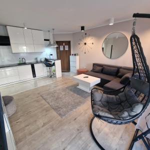 a living room with a couch and a mirror at APARTAMENT OFELIA in Darłówko