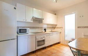 a small kitchen with white cabinets and a table at Nice Apartment In Aguadulce With Wifi in Aguadulce