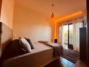 a bedroom with a bed and a large window at Apartamento Poços de Caldas in Poços de Caldas
