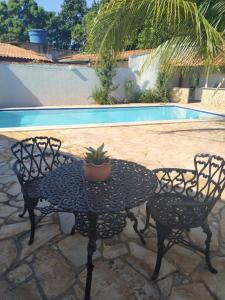 a table with a potted plant on it next to a pool at Zaffir Apartamento in Várzea Grande +8 photos
