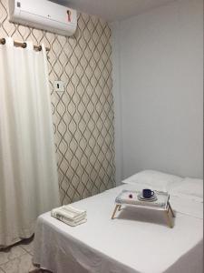 a room with a bed with a table with a plate on it at Zaffir Apartamento in Várzea Grande