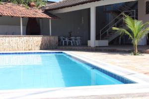 a swimming pool in front of a house at Zaffir Apartamento in Várzea Grande