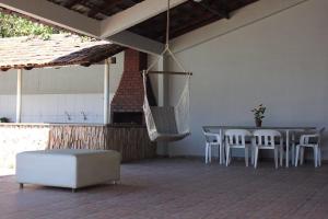 a patio with a table and chairs and a swing at Zaffir Apartamento in Várzea Grande