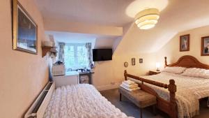 a bedroom with two beds and a kitchen with a window at Coynant Farm Guesthouse - Farm Park Stay in Swansea