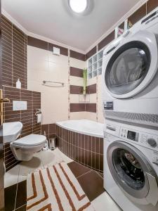 a bathroom with a washing machine and a toilet at President Apartment City Center Kosice Kovacska in Košice