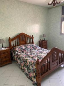 a bedroom with a wooden bed and two night stands at Appartement Belevédère in Casablanca