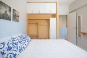Un dormitorio con una cama blanca con sábanas azules y blancas. en Apartamento incrível beira mar, en Natal 8 fotos más