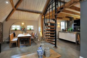 a kitchen and dining room with a spiral staircase in a house at Antoniushofke in Asten
