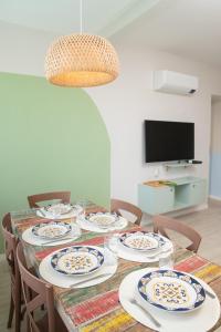 un comedor con una mesa con platos y sillas en Apartamento incrível beira mar, en Natal