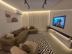 a living room with a couch and a flat screen tv at Madinaty Cozy studio at Privado in New cairo